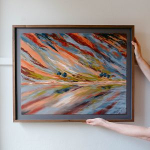 soft pastel framed landscape painting of reflection of an abstract mountain. Blues greens and reds